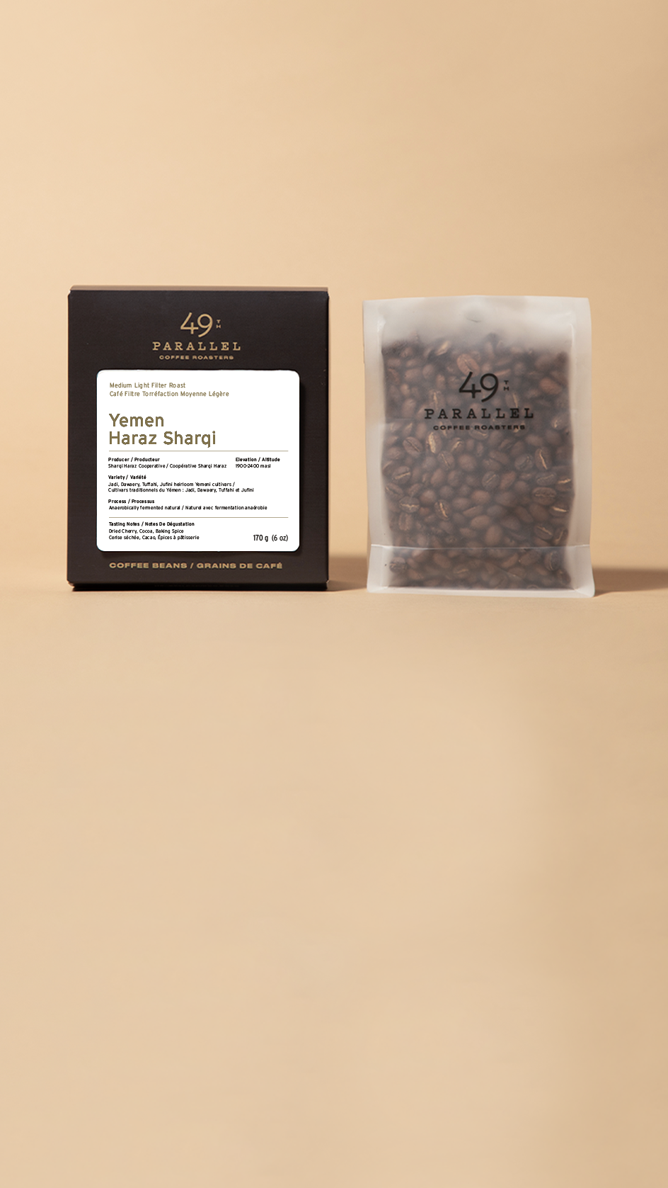 A black coffee box and a clear stand-up pouch filled with dark coffee beans, both branded 49 Paradise Coffee Roasters, displayed side by side on a warm beige background.